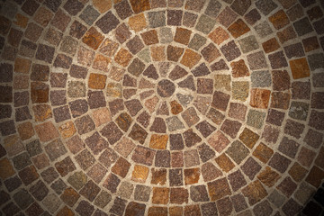 Circular texture of porphyry stone floor called Sanpietrini or Sampietrini, typical urban paving in Italy, Europe