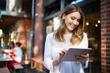 Happy girl working online or studying and learning while using tablet