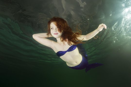 Young red-haired mermaid swims underwater, Ukraine, Europe