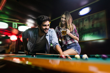 Obraz na płótnie Canvas Couple drinking beer and playing snooker on date