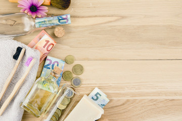 Obraz na płótnie Canvas Set of different zero waste beauty products on wooden background with euro money bank notes around them, zero waste sustainable lifestyle true cost concept. 