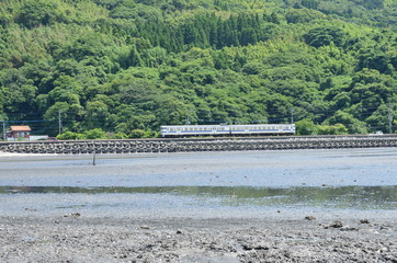 A train traveling between the sea and the mountain
