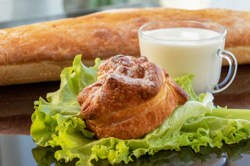 Fresh tasty bread with milk on the background of nature in summer.