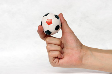 Fototapeta premium Mini ball of football in hand and one black point of football is China flag, hold it with two finger on white background.