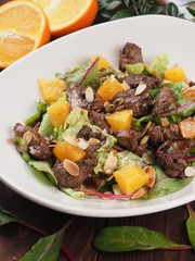 Fried meat with orange sauce on a white plate