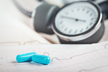 Medical pills on the background of ECG, cardiogram and cardiac gauge.  Diagonics, prevention and...