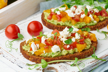 avocado toast with feta and tomatoes, smorrebrod with ricotta, closeup