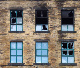 broken windows in a large burned out old industrial building after a fire