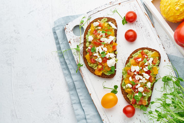 avocado toast with feta and tomatoes, smorrebrod with ricotta, top view with copy space