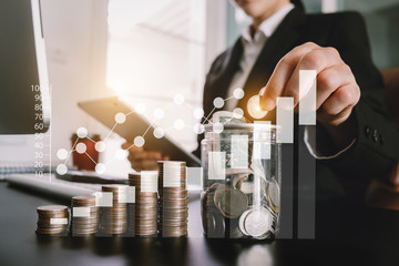 businessman holding coins putting in glass with using smartphone and calculator to calculate  concept saving money for finance accounting
