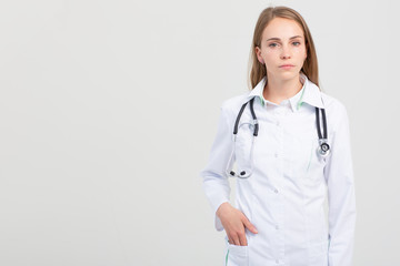 Female smiling doctor armcrossed portrait on gray