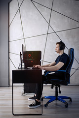 Professional gamer in his expensive studio young man having live stream playing online video game. Cyber sportsman is streaming popular pc computer game for his followers      © D'Action Images