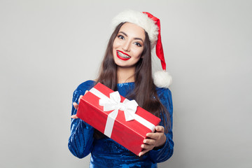 Pretty woman in braces holding Christmas or New Year gift and smiling