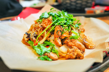 Wicker plate of traditional vietnamese dish - glass noodles with chicken meat and vegetables