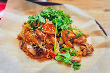 Wicker plate of traditional vietnamese dish - glass noodles with chicken meat and vegetables