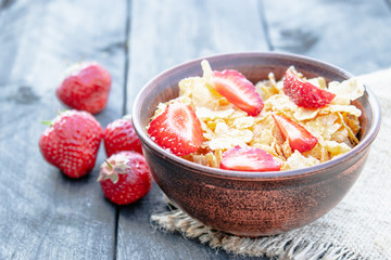 Fresh homemade muesli, muesli with strawberries in a plate on a dark gray background, selective focus
