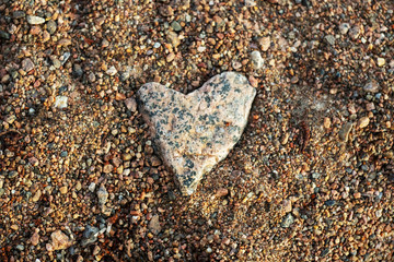 Stone heart lies in the sand.