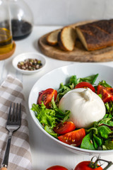 Fresh salad with italian burrata cheese, juicy tomatoes, balsamic vinegar and olive oil