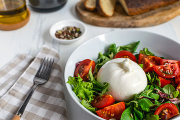 Fresh salad with italian burrata cheese, juicy tomatoes, balsamic vinegar and olive oil