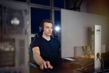 Professional gamer in his expensive studio young man having live stream playing online video game. Cyber sportsman is streaming popular pc computer game for his followers    