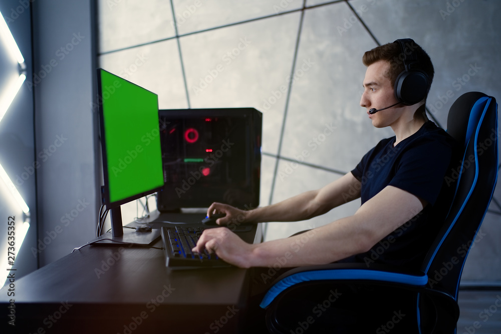 Wall mural Professional gamer playing online video game at night time