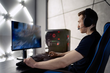 Professional gamer in his expensive studio young man having live stream playing online video game. Cyber sportsman is streaming popular pc computer game for his followers     © D'Action Images