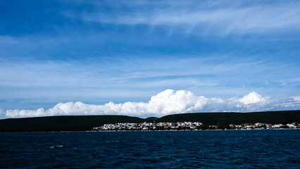 Landscape with the birds flying above adriatic sea with nice white cloiuds