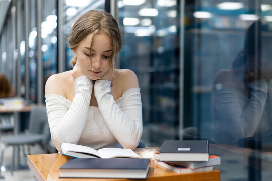 a girl in a bookstore is reading a book, preparing for a new school year. Theme education, personal development. Copy space