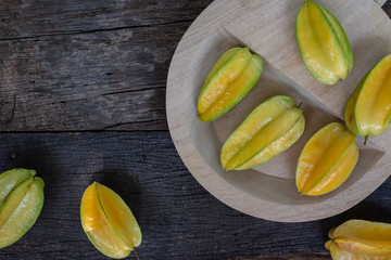 Fresh organic cut star fruit on wooden chopping board
