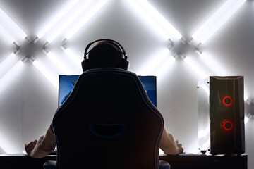 Professional gamer in his expensive studio young man having live stream playing online video game. Cyber sportsman is streaming popular pc computer game for his followers     © D'Action Images