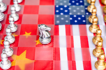 Chess board game pieces on USA and China flag background, trade war tension situation concept