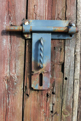 Rusty rural  handmade  lock  on aged wooden  shed door