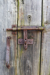 Rusty rural  handmade  lock  on aged wooden village barn door