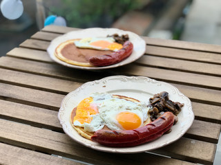 Bratwurst Sausage German Breakfast with Pancake, Fried Eggs and Mushrooms.