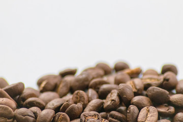 Ganze Kaffeebohnen vor neutralem Hintergrund symbolisieren Kaffeegenuss für echte Kaffeeliebhaber