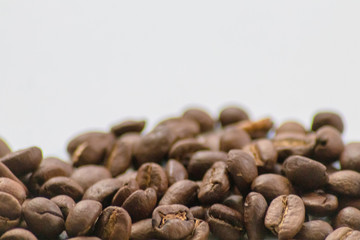 Ganze Kaffeebohnen vor neutralem Hintergrund symbolisieren Kaffeegenuss für echte Kaffeeliebhaber