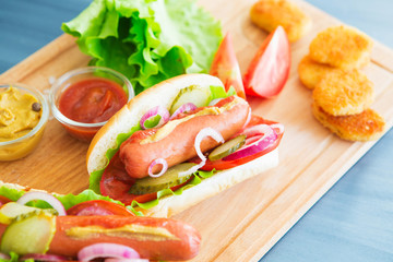 Delicious fast food. Hot dogs with vegetables on wooden table