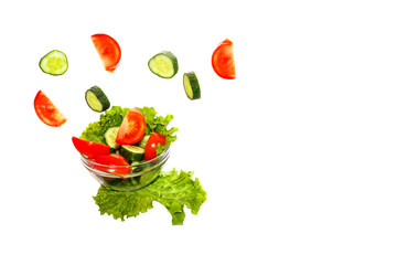 fresh vegetables falling into a plate on a white background in slow motion