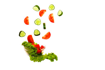 fresh vegetables falling into a plate on a white background in slow motion