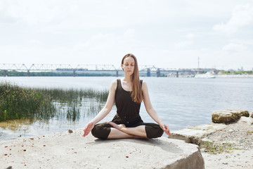 Fototapeta na wymiar Young attractive woman doing dancers yoga pose outdoor