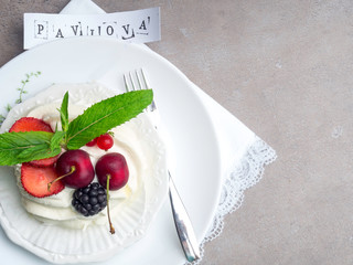 Meringues Pavlova cakes with fresh berry on concrete background, top view