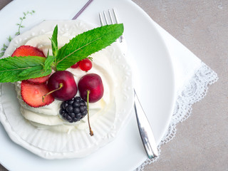 Pavlova meringue cake with fresh berries on white plate