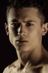 Muscle strong beautiful stripped male model portrait on black isolated font background