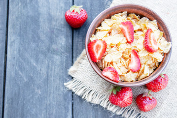 Fresh homemade muesli, muesli with strawberries in a plate on a dark gray background, selective focus