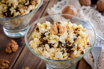 Festive salad of walnut, chicken and prunes in glass salad bowls, horizontal