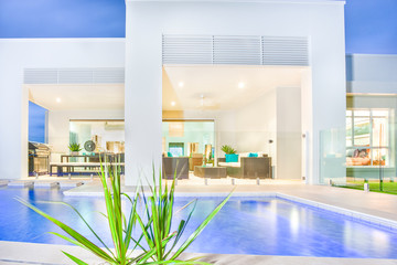 Close up of modern swimming pool near luxury home.