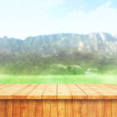 Wood table top on blur mountains background. Nature concept of landscape. Empty brown wooden table on natural background for montage product display or design key visual layout.