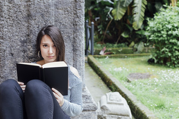 Girl reading a book in the garden