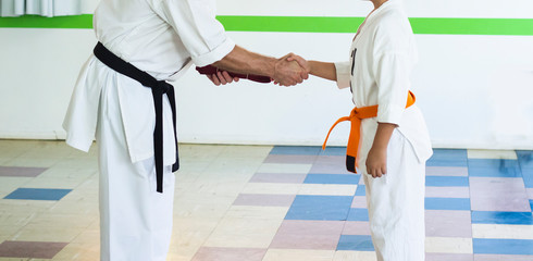 Athlete receiving Karate belt from sensei.
