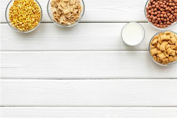 Cereals and flakes from corn and oat on white wooden background top view mockup